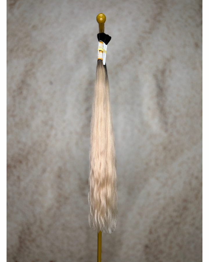 Four bundles of medium blond with deep dark roots body wavy bulk hair arranged together.